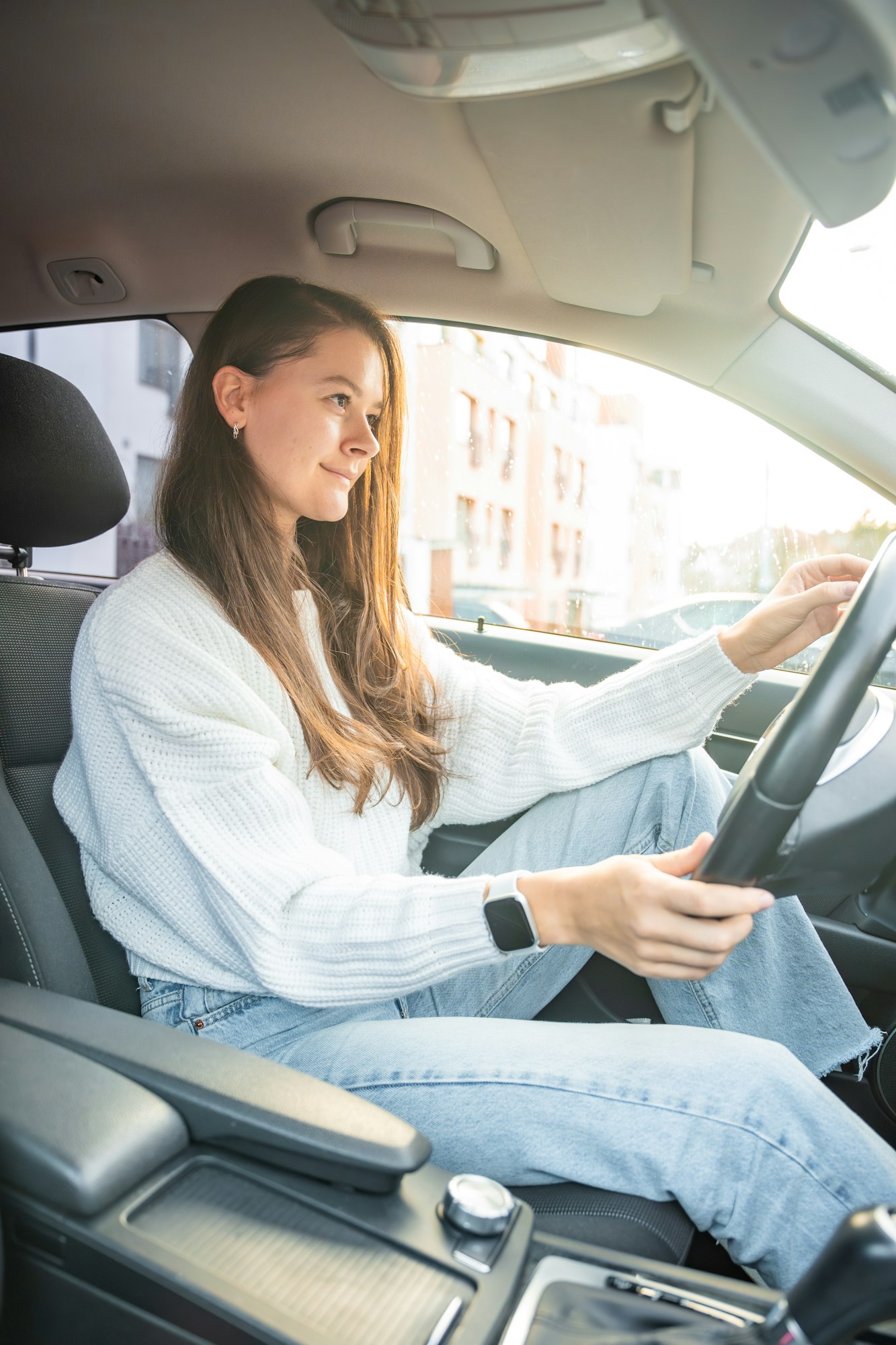 Side portrait of young caucasian woman driving car in the city